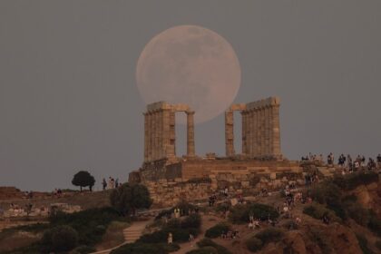 A full moon in the sky over the ancient Temple of Poseidon at Cape Sounion