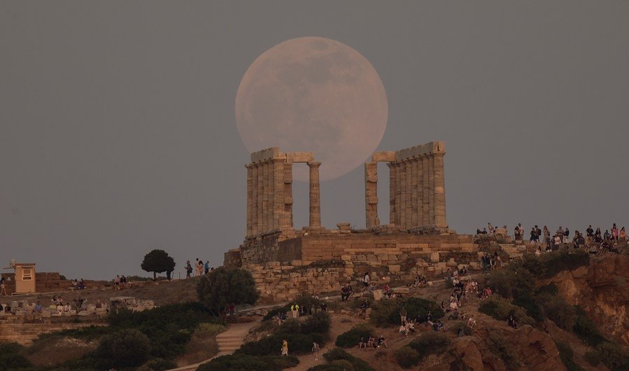 A full moon in the sky over the ancient Temple of Poseidon at Cape Sounion