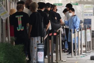 People stand in line to take coronavirus tests