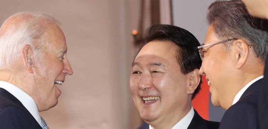 South Korean President Yoon Suk-yeol (C) talks with U.S. President Joe Biden