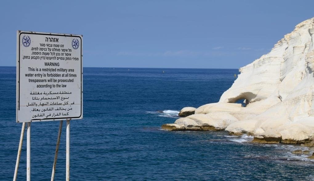 A warning sign is seen by the sea in northern Israel's Rosh Hanikra bordering Lebanon.jpg