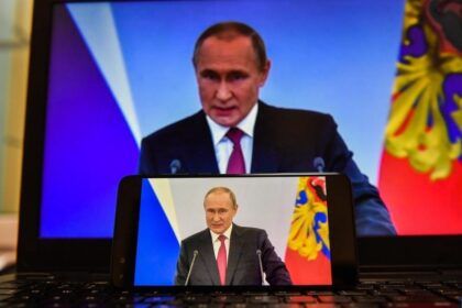 Screens displaying Russian President Vladimir Putin delivering a speech
