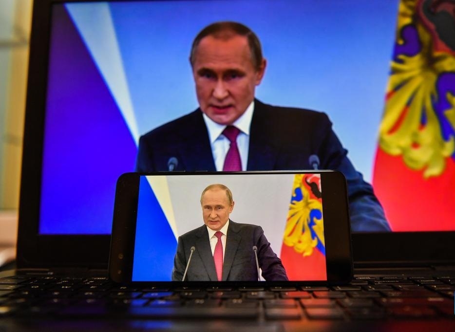 Screens displaying Russian President Vladimir Putin delivering a speech