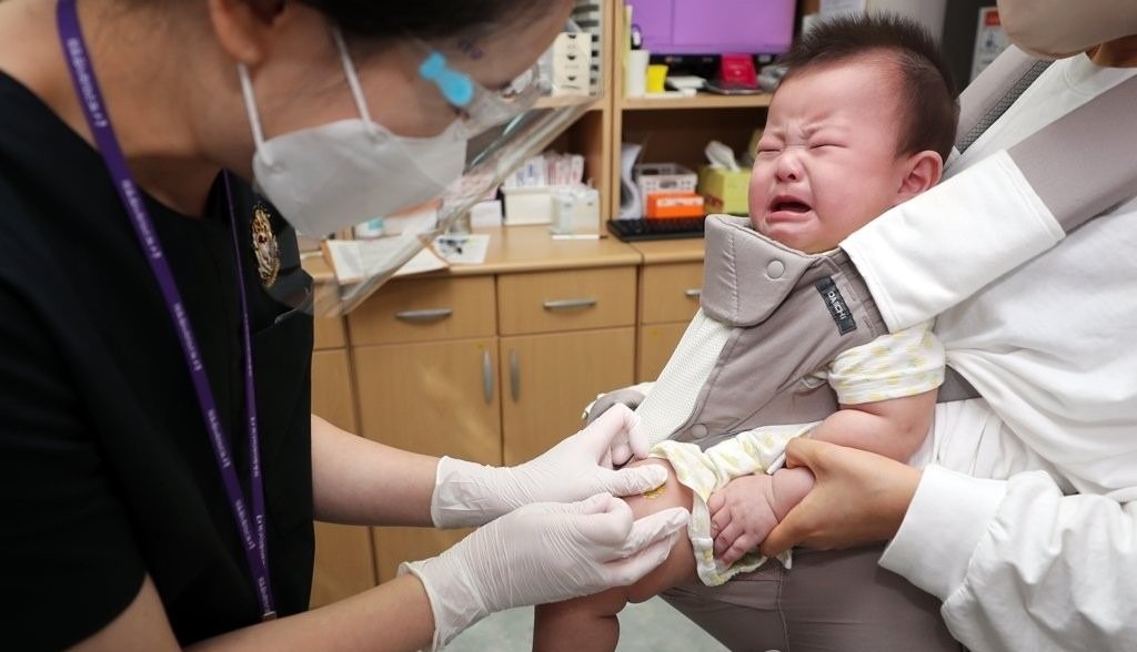 A baby gets a flu shot at a hospital in Gwangju