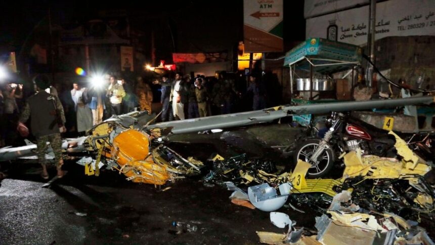 Yemeni people gather at the site where a drone crashed
