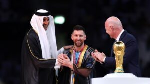 Emir of Qatar placing a robe on Messi at presentation ceremony