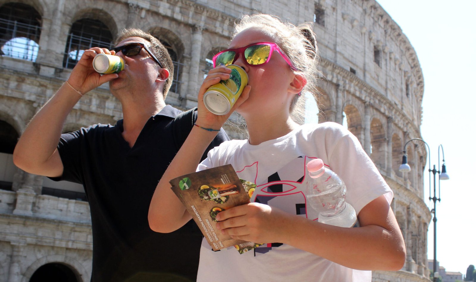Tourists drink under the sun in front of the Colosseum