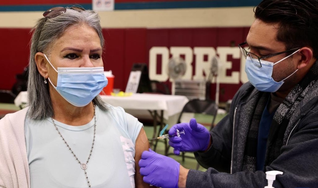 A health worker administers a flu vaccine shot to a local resident in Los Angeles