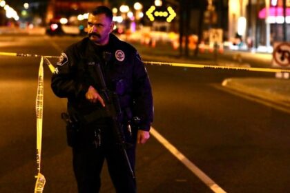 A police officer stands guard on the scene of a mass shooting