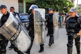 Police officers arrive at a prison after a clash