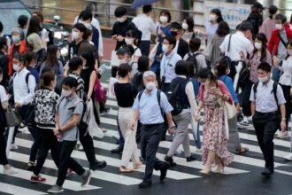 Pedestrians walk across a street in Tokyo, Japan