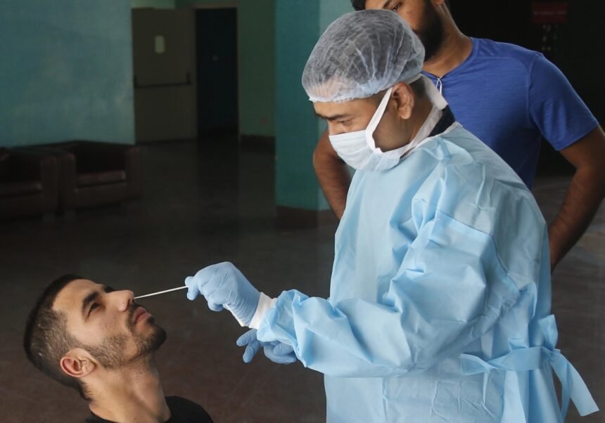 A health worker collects a nasal sample