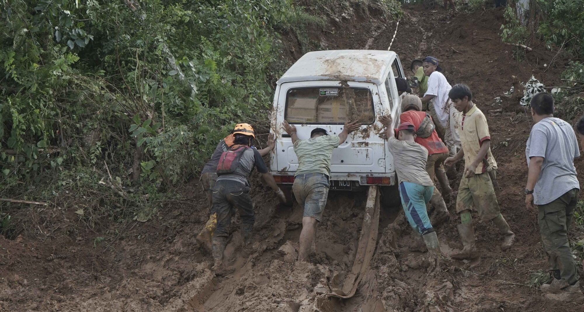 Villagers try to move a van