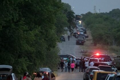 People gather at the scene of an alleged human smuggling mass