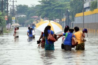People wade through water in suburban areas of Colombo