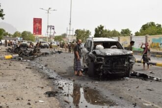 Security forces inspect the site where a motorcade of a Yemeni military official was attacked by a car bomb in Aden