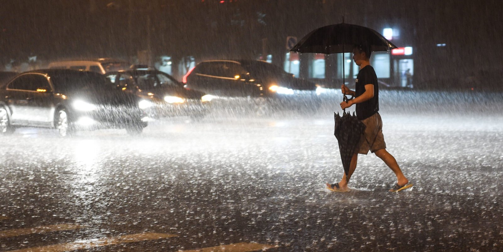 A citizen walks at a rainy night in Beijing