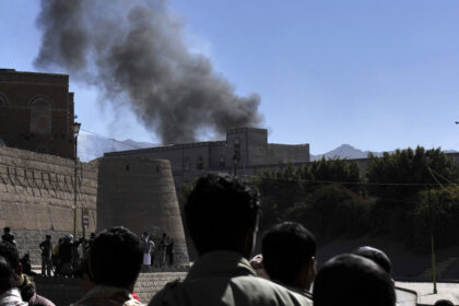 People watch smoke rise from the Defense Ministry in Sanaa
