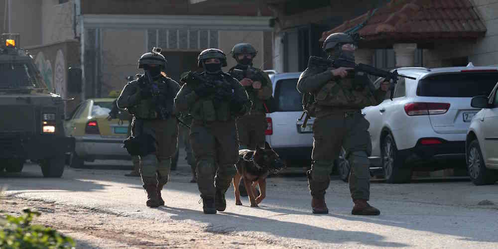 Israeli soldiers patrol a street in Salem village